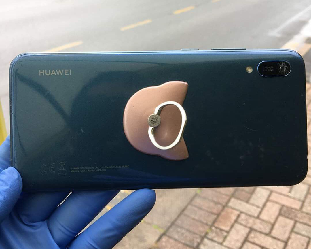A member of the public wearing gloves when handling a phone.